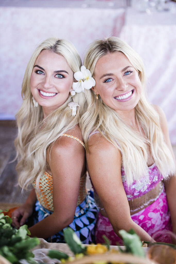 Matias Ezcurra Photography, Twin sisters smiling, wearing summer dresses and flower crowns for their Olowalu Plantation wedding weekend.