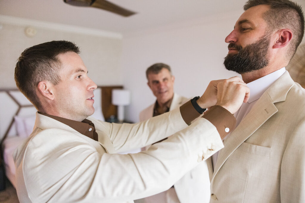 Matias Ezcurra Photography, Groom getting ready at Grand Wailea Maui wedding, groomsman adjusting his tie.