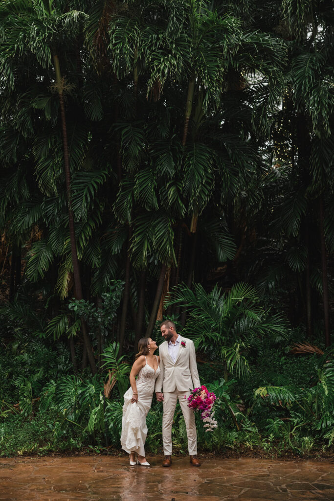 Matias Ezcurra Photography, Grand Wailea Maui wedding photo of a bride and groom standing in front of lush tropical foliage.