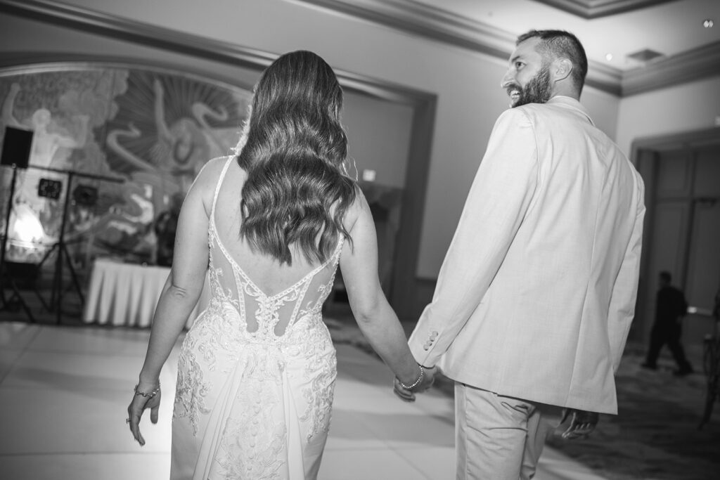 Matias Ezcurra Photography, Grand Wailea Maui wedding: Bride and groom holding hands, walking on the dance floor.