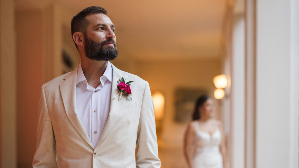 Matias Ezcurra Photography, Groom in linen suit at Grand Wailea Maui wedding, bride in background.