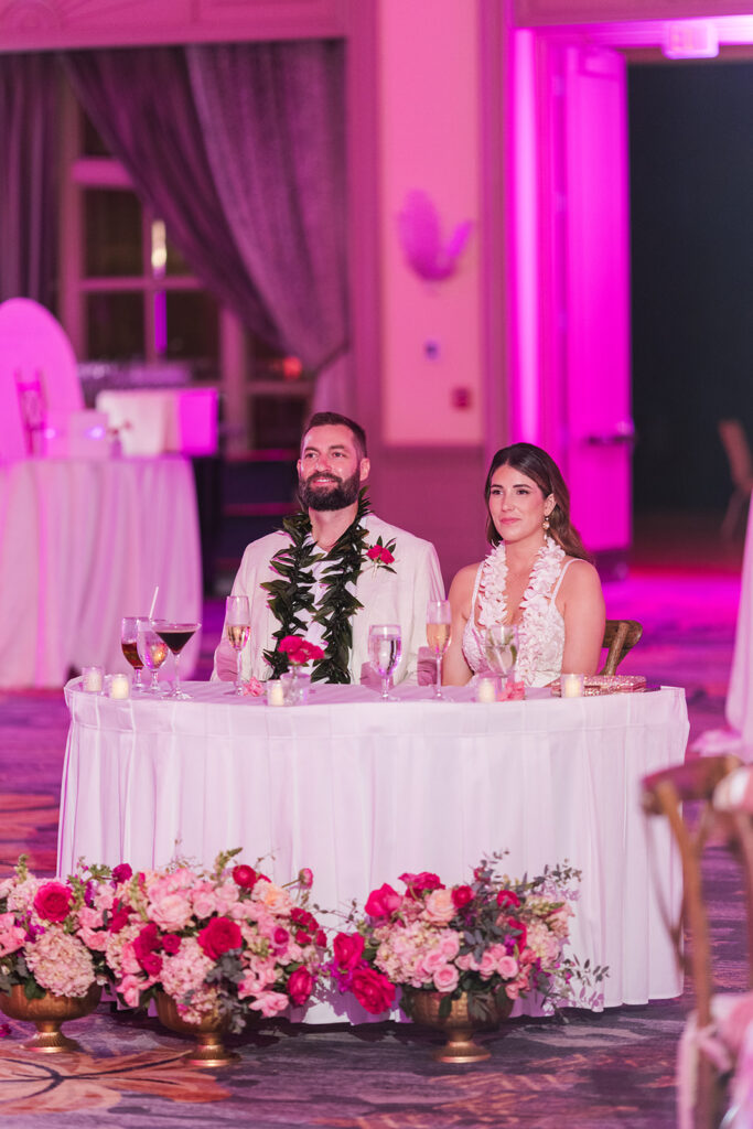 Matias Ezcurra Photography, Grand Wailea Maui wedding: Bride and groom at sweetheart table with leis.