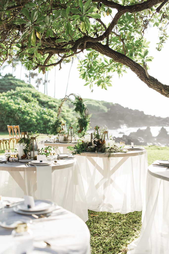Matias Ezcurra Photography, Luxury Maui wedding reception tables set outdoors under a tree.