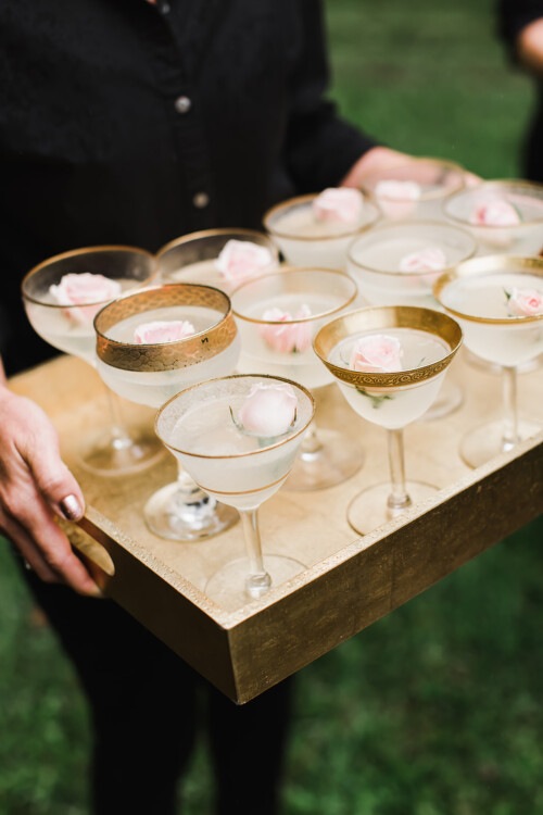 Matias Ezcurra Photography, Gold tray of champagne cocktails garnished with pink roses at a Haiku Mill wedding.