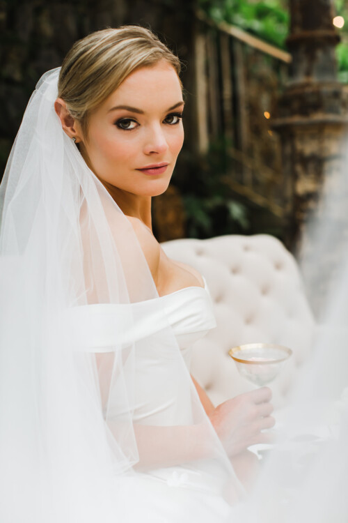 Matias Ezcurra Photography, Elegant bride in off-the-shoulder gown, holding a cocktail at her Haiku Mill wedding.