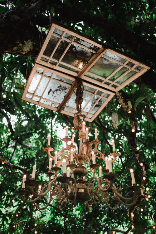 Matias Ezcurra Photography, Ornate chandelier hangs beneath repurposed window panes at a Haiku Mill wedding.