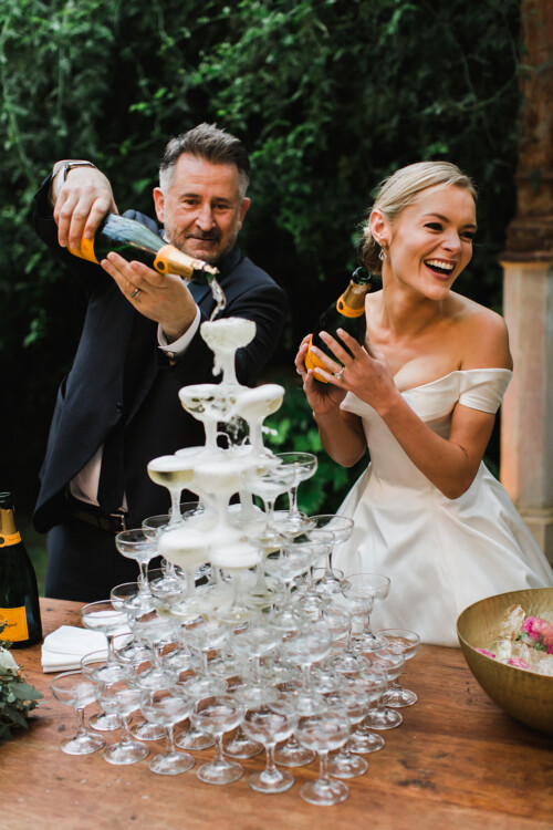 Matias Ezcurra Photography, Bride and groom pouring champagne into a wedding champagne tower at their Haiku Mill wedding.