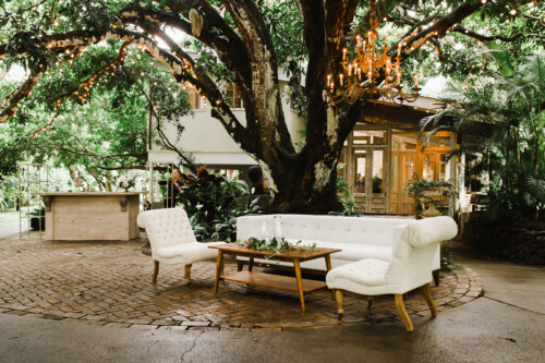 Matias Ezcurra Photography, Elegant outdoor wedding seating under a tree with string lights at Haiku Mill. White sofa and chairs.