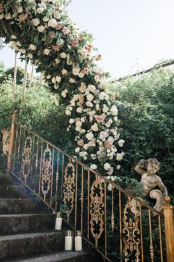 Matias Ezcurra Photography, Ornate iron railing with cascading floral wedding arch at Haiku Mill.