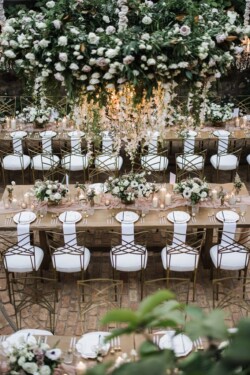 Matias Ezcurra Photography, Elegant wedding reception at Haiku Mill with long tables, white chairs, and a stunning floral chandelier.