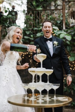 Matias Ezcurra Photography, Bride and groom joyfully pouring champagne into a wedding champagne tower at their Haiku Mill wedding.