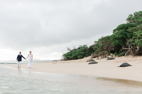 Matias Ezcurra Photography, Bride and groom holding hands on a beach with sea turtles