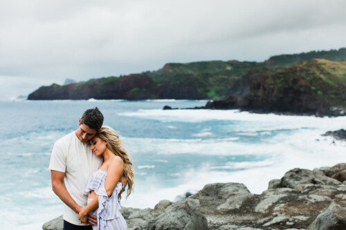 Matias Ezcurra Photography, Arie and Lauren embrace on a Maui beach, ocean waves in the background.