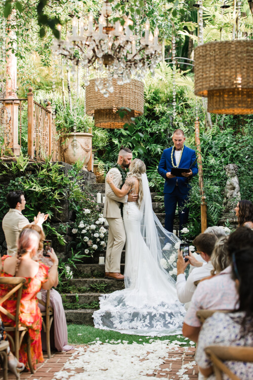 Matias Ezcurra Photography, Bride and groom kiss at their Haiku Mill wedding ceremony. Guests watch the couple exchange vows.