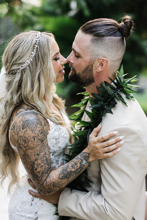 Matias Ezcurra Photography, Bride and groom embrace at Haiku Mill wedding; she has tattoos, he wears a lei.