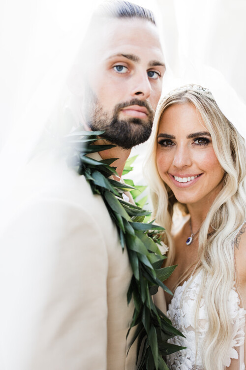 Matias Ezcurra Photography, Happy newlyweds, Jessica & Mike, at Haiku Mill wedding. Bride in white lace dress, groom in beige suit with lei.