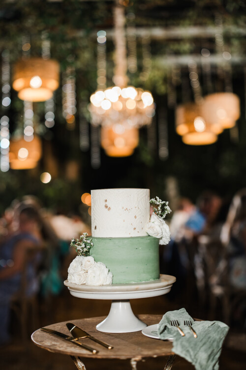 Matias Ezcurra Photography, Two-tiered wedding cake at Haiku Mill wedding. Sage green and white frosting with white flowers.