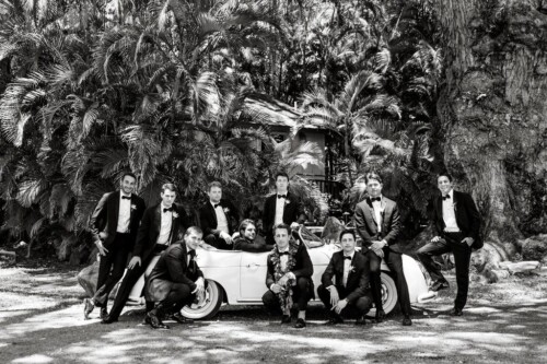 Matias Ezcurra Photography, Groomsmen in tuxedos pose with a classic white Porsche at an Olowalu Plantation wedding.