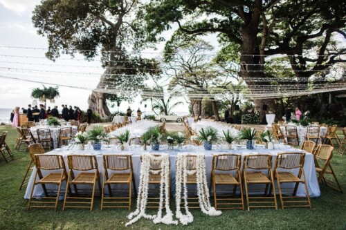 Matias Ezcurra Photography, Elegant outdoor wedding reception at Olowalu Plantation with long head table and bamboo chairs.