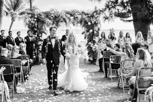 Matias Ezcurra Photography, Bride and groom walking down the aisle at their Olowalu Plantation wedding, showered with flower petals.
