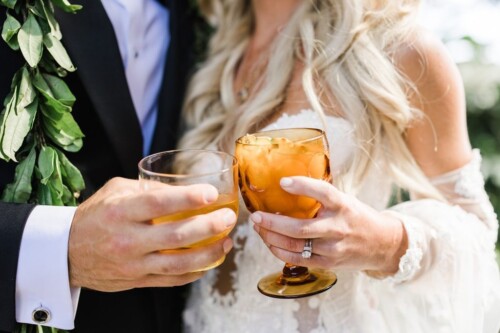 Matias Ezcurra Photography, Bride and groom clinking glasses at their Olowalu Plantation wedding.
