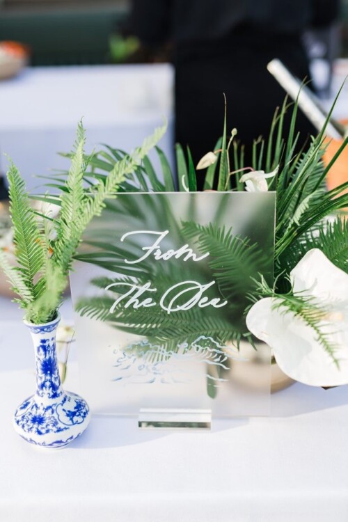 Matias Ezcurra Photography, Frosted acrylic sign reading "From the Sea" at an Olowalu Plantation wedding, surrounded by tropical greenery.