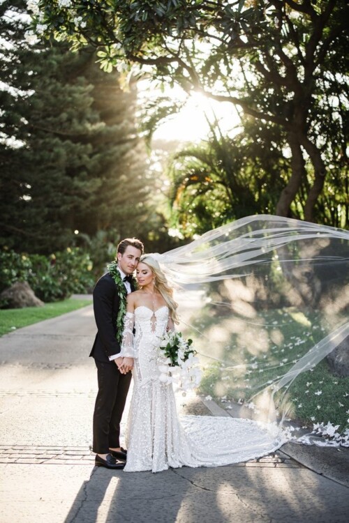 Matias Ezcurra Photography, Bride and groom embrace on a sun-drenched path at their Olowalu Plantation wedding.