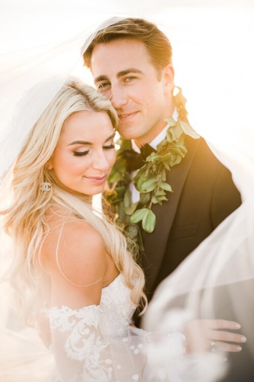 Matias Ezcurra Photography, Bride and groom embrace under a veil at their Olowalu Plantation wedding.