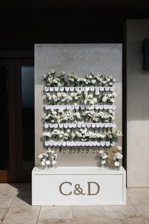 Matias Ezcurra Photography, Wedding seating chart with white flowers and "We picked your seat" sign. C&D initials on base.
