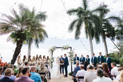 Matias Ezcurra Photography, Outdoor wedding ceremony with bride and groom exchanging vows under floral archway.