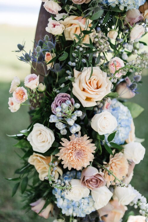 Matias Ezcurra Photography, Elegant wedding arch adorned with peach, blush, and white roses, hydrangeas, and dusty miller.