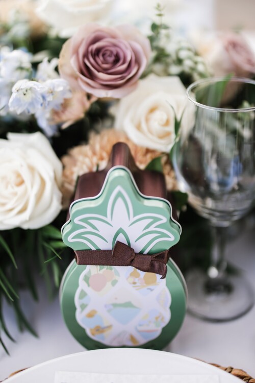 Matias Ezcurra Photography, Pineapple-shaped tin favor at wedding reception, surrounded by flowers.