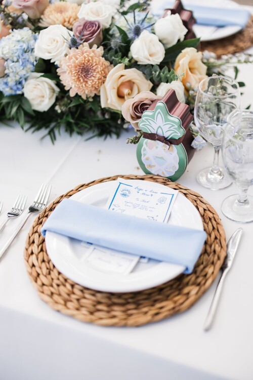 Matias Ezcurra Photography, Wedding table setting with blue napkin, place card, and woven charger. Beach wedding theme.