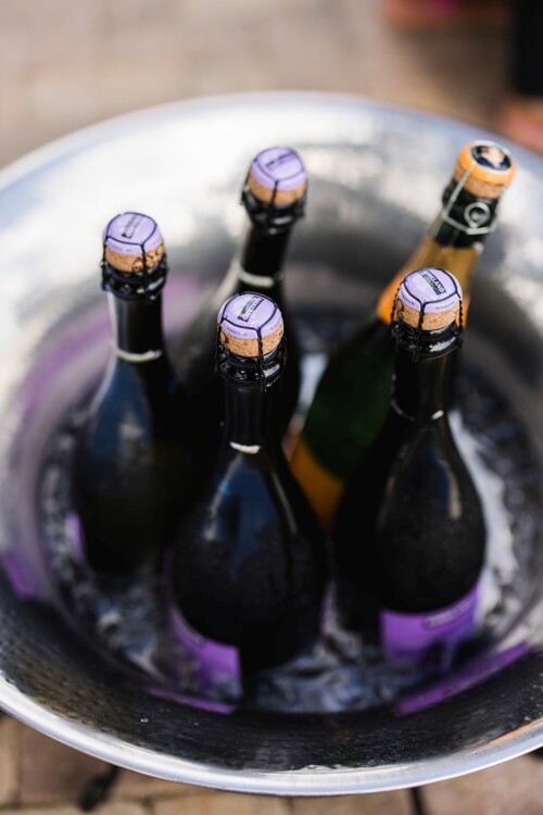 Matias Ezcurra Photography, Four bottles of chilled sparkling wine in a metal ice bucket.