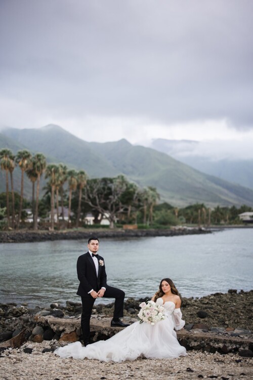Matias Ezcurra Photography, Bride and groom pose by the ocean at Olowalu Plantation House, Maui.