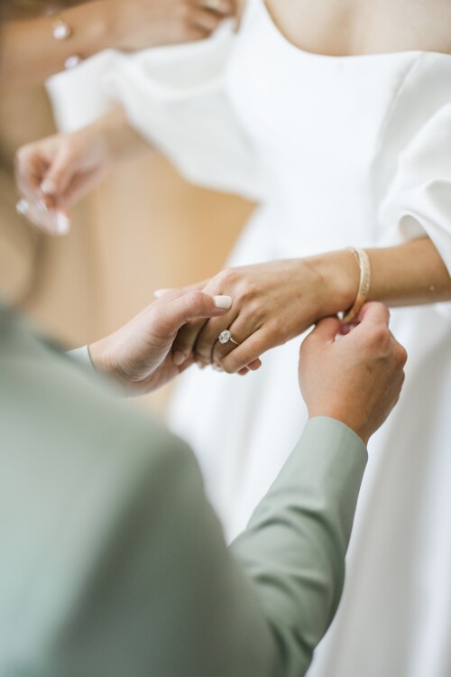 Matias Ezcurra Photography, Groom placing wedding ring on bride's finger at Kualoa Ranch wedding.