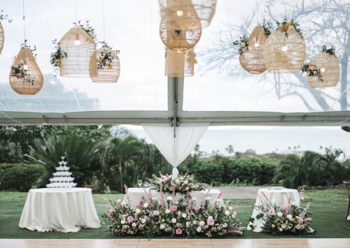 Matias Ezcurra Photography, Elegant wedding reception at Kualoa Ranch with floral arrangements and hanging lanterns.