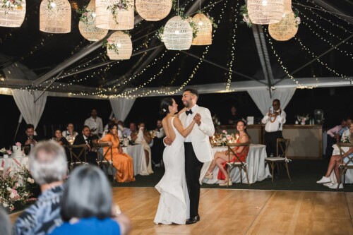 Matias Ezcurra Photography, Bride and groom's first dance at their Kualoa Ranch luxury wedding. Elegant outdoor reception.