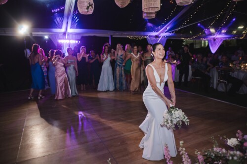 Matias Ezcurra Photography, Bride throws bouquet at Kualoa Ranch wedding reception.