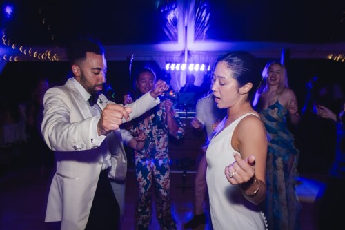 Matias Ezcurra Photography, Bride and groom joyfully dancing at their Kualoa Ranch wedding reception.