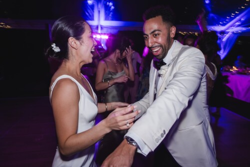 Matias Ezcurra Photography, Happy bride and groom dancing at their Kualoa Ranch wedding reception.