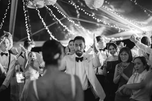 Matias Ezcurra Photography, Groom and guests celebrate at a Kualoa Ranch wedding reception.