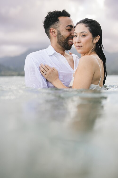 Matias Ezcurra Photography, Happy couple embracing in the water at Kualoa Ranch. Klaire & Alex's wedding.