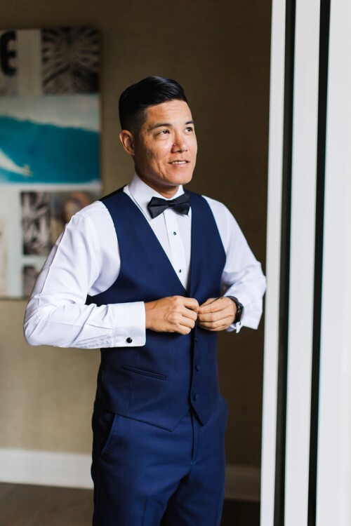 Matias Ezcurra Photography, Groom in navy blue suit vest and bow tie, preparing for wedding