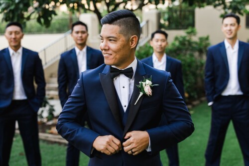 Matias Ezcurra Photography, Groom in navy tuxedo with groomsmen in background