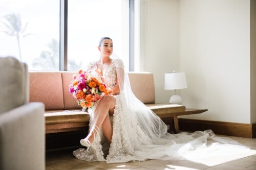 Matias Ezcurra Photography, Bride in lace wedding dress holds vibrant bouquet, Andaz Maui wedding.