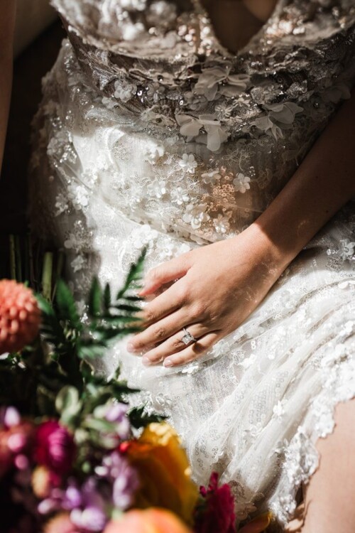 Matias Ezcurra Photography, Bride's hand with engagement ring rests on her lace wedding dress at her Andaz Maui wedding.
