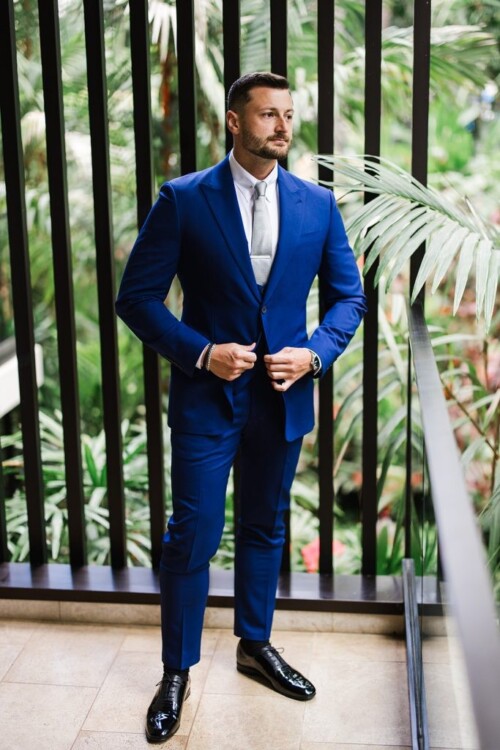 Matias Ezcurra Photography, Groom in blue suit and black shoes poses for wedding photo at Andaz Maui.