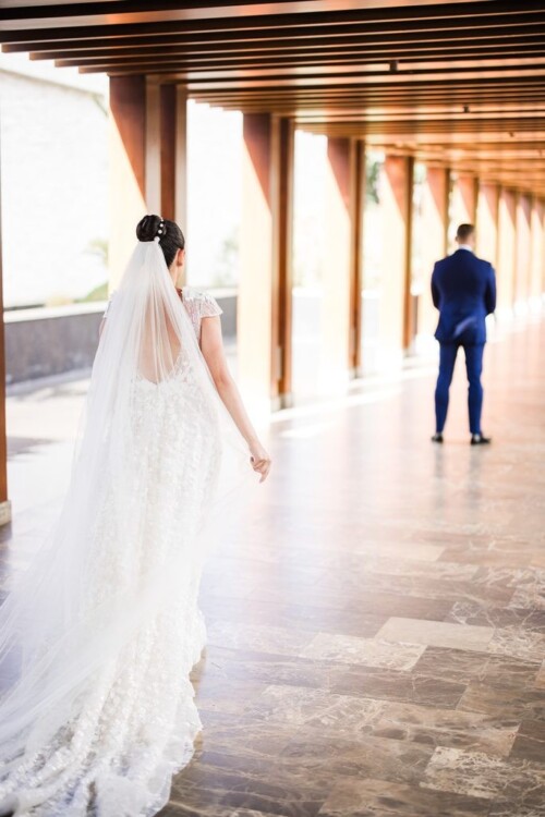 Matias Ezcurra Photography, Bride in wedding dress approaches groom during first look at Andaz Maui wedding.