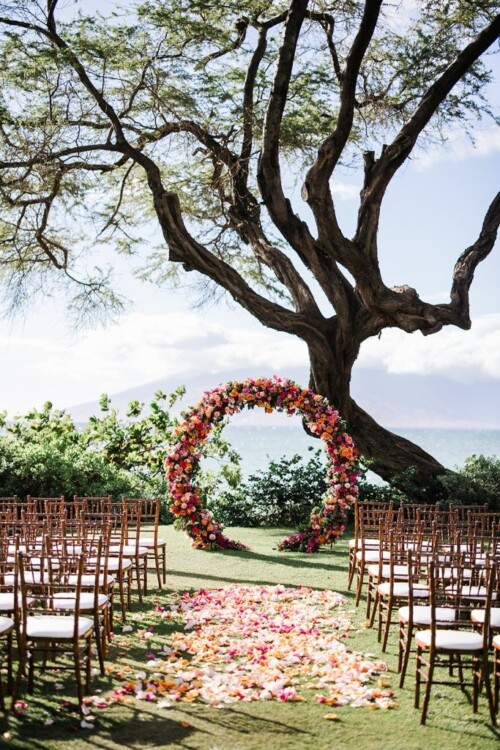 Matias Ezcurra Photography, Floral wedding ceremony arch at Andaz Maui. Rows of chairs face the ocean view.